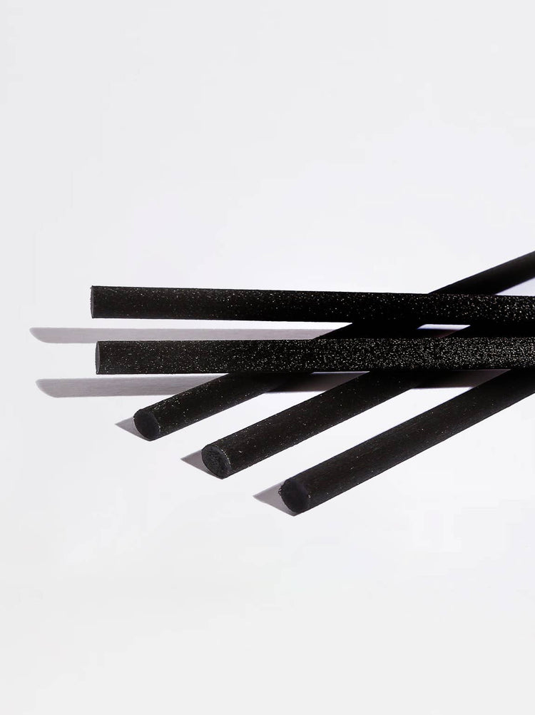 Five black foam straws with a textured surface, arranged diagonally on a clean white background.