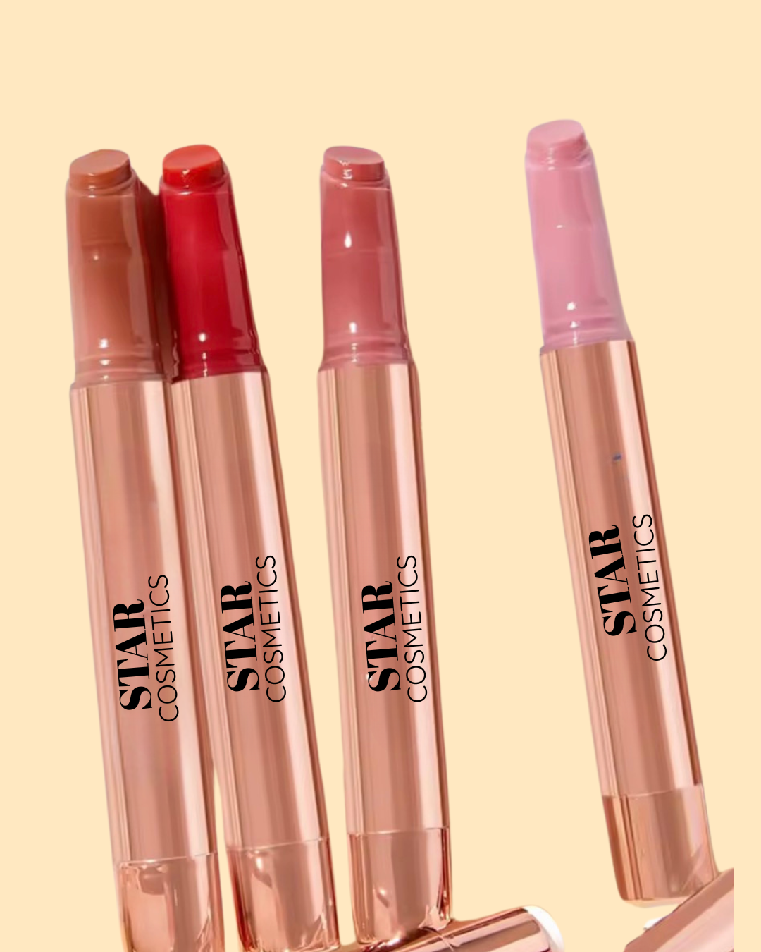A Star Cosmetics lip balm in different shades in light brown, red, peach pink on a beige background