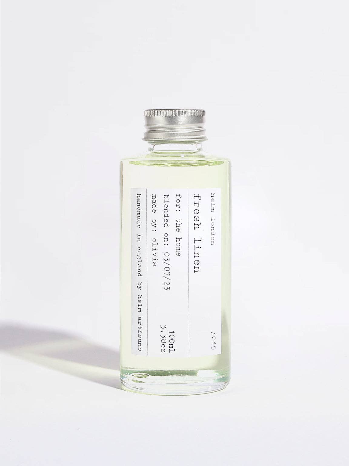 A clear glass bottle of Fresh Linen room spray with a silver metal cap, containing a pale yellow-green liquid, set against a plain white background.