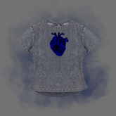 A gray mineral-wash t-shirt featuring a detailed blue anatomical heart graphic on the chest, presented against a smoky gray background.