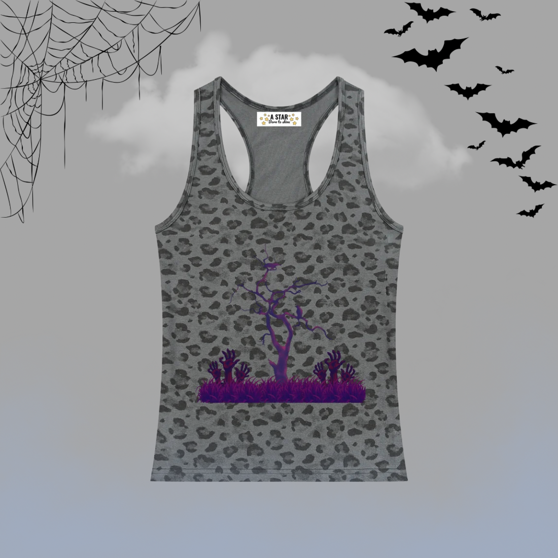 A gray racerback tank top with a black leopard print pattern and a purple Halloween-themed graphic of a bare tree and spiky plants on the front. The tank top is displayed against a gray background with spooky decorative elements including black spiderwebs in the top-left corner, black bats flying in the top-right, and a light blue-gray gradient at the bottom.