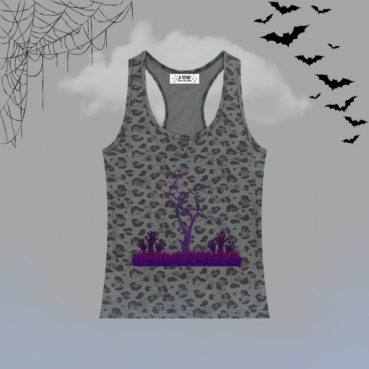 A gray racerback tank top with a black leopard print pattern and a purple Halloween-themed graphic of a bare tree and spiky plants on the front. The tank top is displayed against a gray background with spooky decorative elements including black spiderwebs in the top-left corner, black bats flying in the top-right, and a light blue-gray gradient at the bottom.