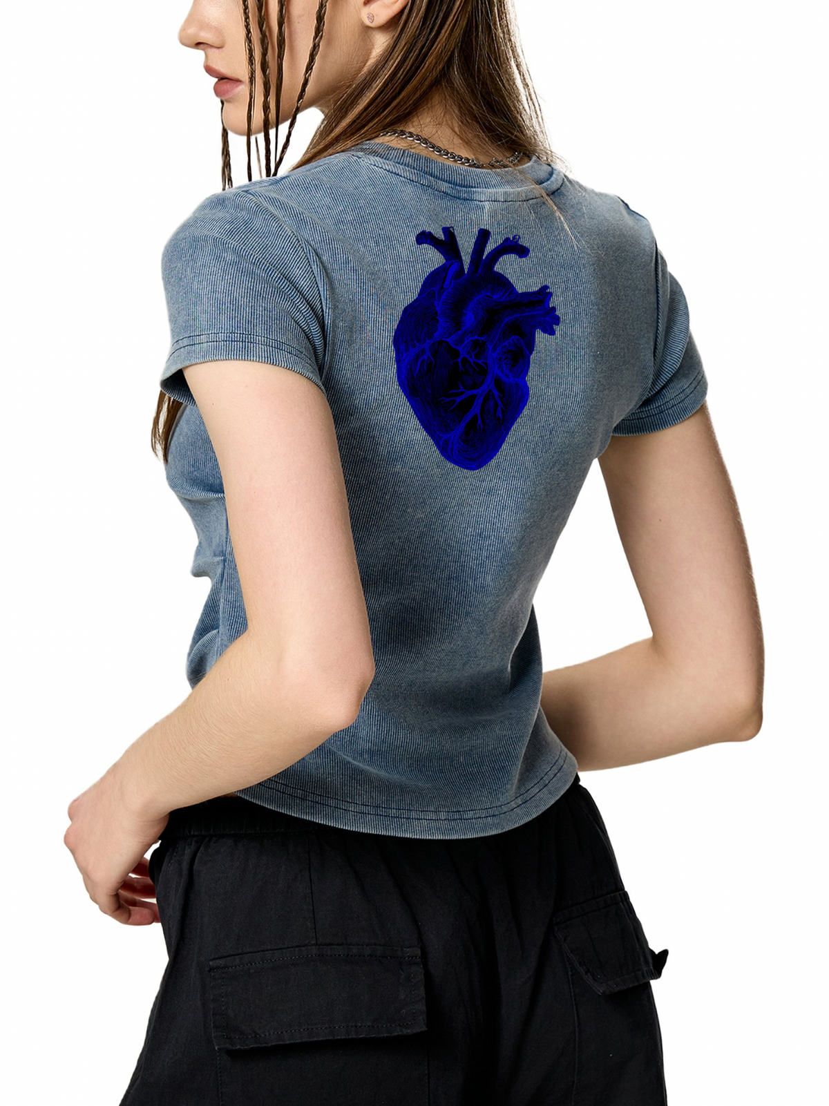 A woman shown from the back wearing a faded blue-gray cropped T-shirt with a large dark blue anatomical heart graphic on the upper back, paired with black cargo pants against a plain white background.