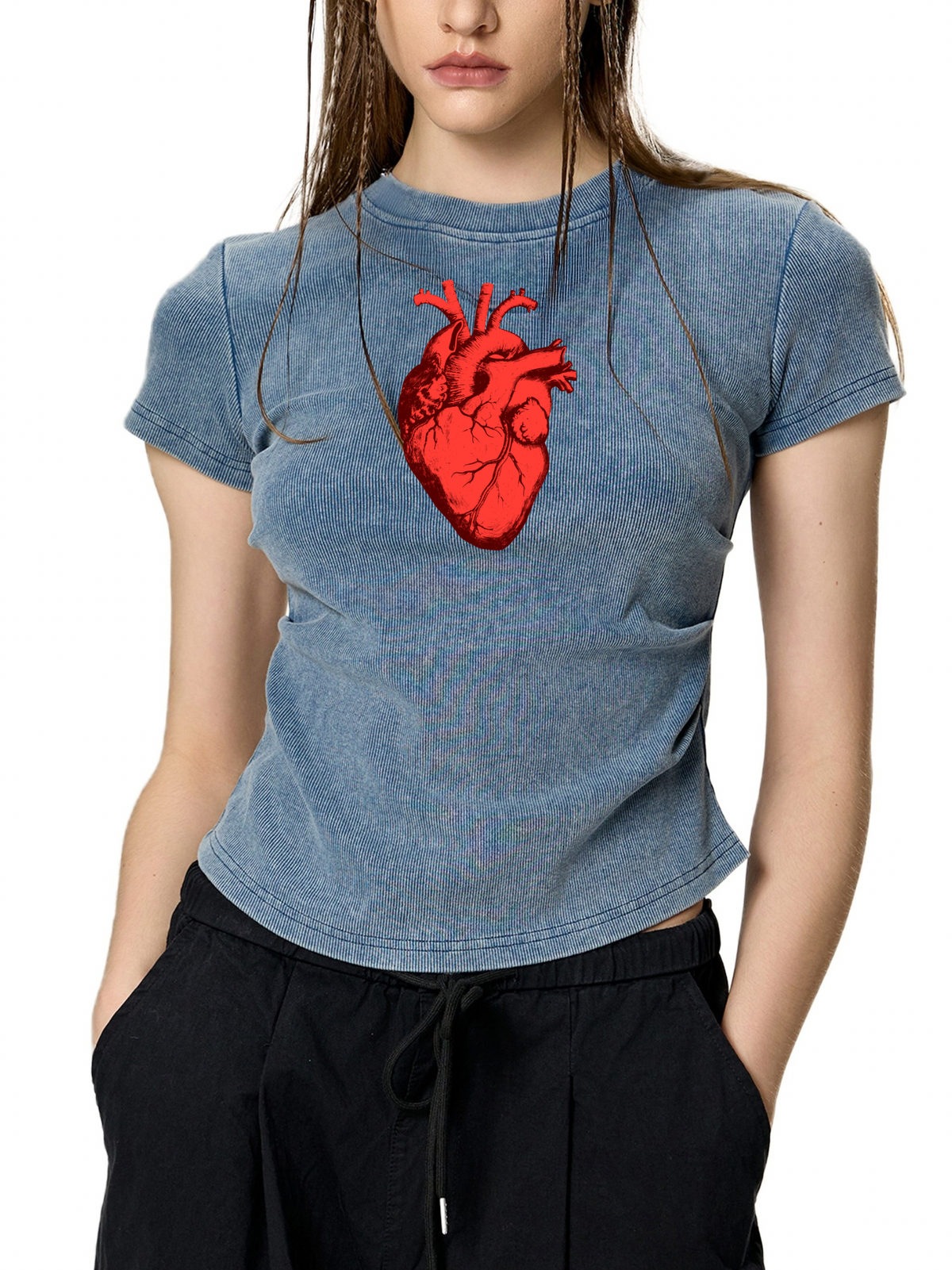 A woman wearing a blue-gray mineral-wash t-shirt with a red anatomical heart graphic on the chest, paired with black drawstring pants, against a plain white background.