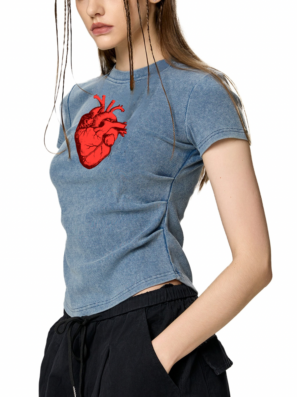 A woman wearing a cropped, heathered blue t-shirt with a red anatomical heart graphic on the chest, paired with black drawstring pants, against a plain white background.