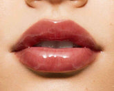 Close-up of a woman with glossy maroon pink lip balm 