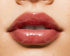 Close-up of a woman with glossy maroon pink lip balm 