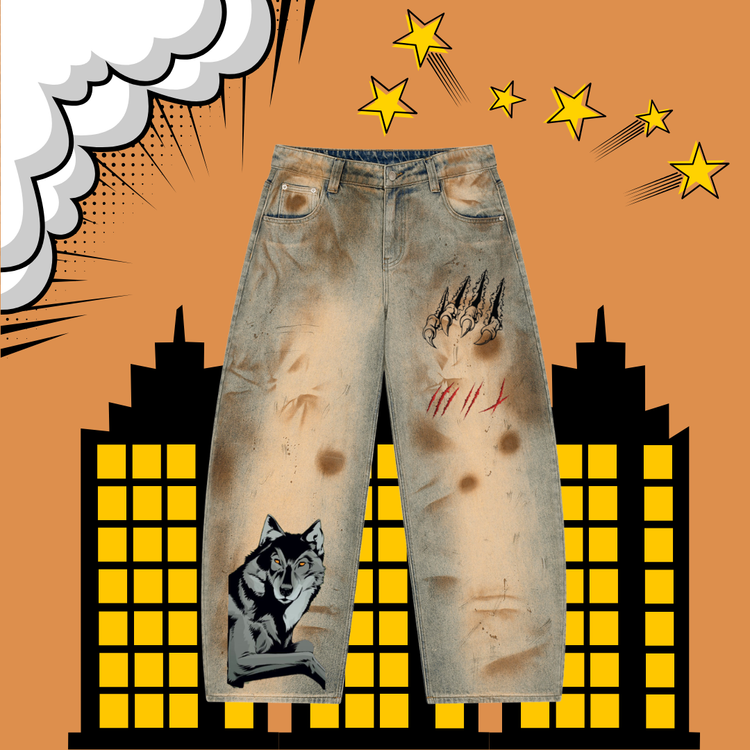 Distressed light-wash denim jeans with horror-themed graphic prints, including a wolf on one leg, claw marks on the other thigh, and red scratch marks, shown against a comic-style orange background with yellow stars and buildings.