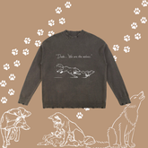 A dark charcoal grey crewneck sweater with a white graphic of a wolf and dog and the text &