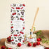 Reed diffuser with cherry design packaging on a wooden surface