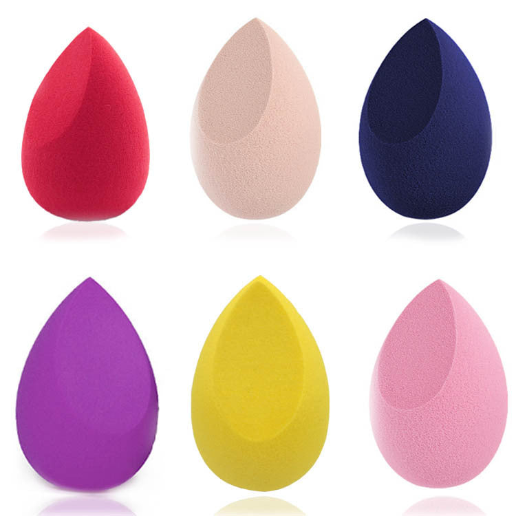 Set of six colourful makeup sponges on a white background