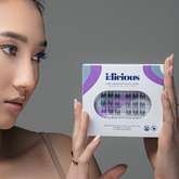 Woman holding a box of i:licious false eyelashes against a grey background